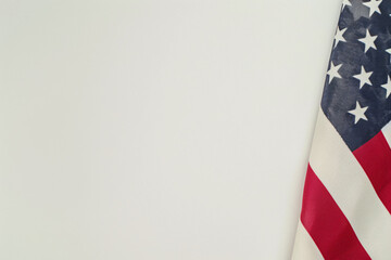 A minimalist image honoring Independence Day and Veterans Day, featuring a prominently displayed American flag against a clean, simple background. The flag's vivid red, white, and blue colors stand