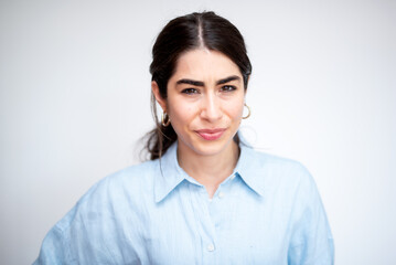 Fototapeta premium beautiful brunette short-sighted woman with light blue shirt on white background 