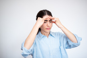 Young woman suffering from a strong headache is touching her temples with fingers