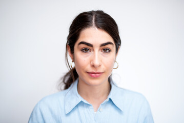 Fototapeta premium beautiful brunette woman portrait with light blue shirt on white background 