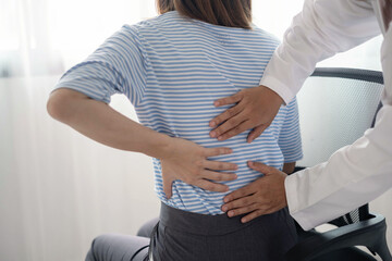 Female physiotherapists provide physical assistance to women patients with back injuries back...