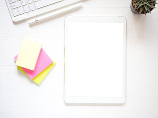 Template, mock-up digital tablet pc computer with blank white screen and pen, keyboard, post-it on white wooden background. Top view, flat lay business background. .