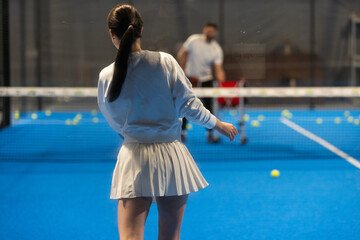 Naklejka premium Young Girls Is Playing Padel on an Court.