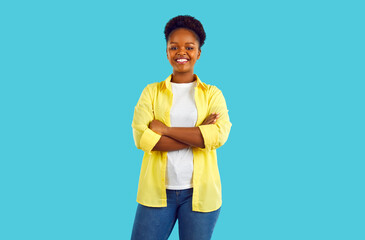 Attractive african woman with short hair in a white T-shirt, yellow shirt and blue jeans.Smiling at...