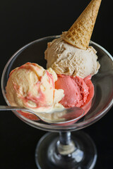 Coppa di vetro elegante servita in un bar con del gelato alla frutta guarnito con una cono croccante