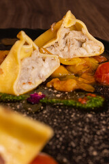 Fagottino di pasta fresca ripieno di funghi porcini con salsa ai 3 pomodori e guanciale croccante servito come primo piatto in un ristorante