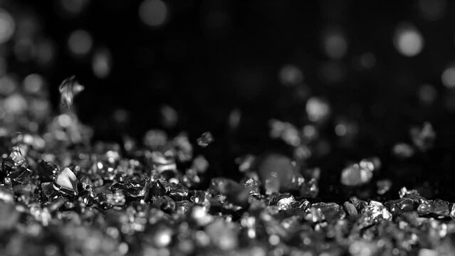 Black сopper slag crystals being poured. Close up. Black sand pouring in slow motion.