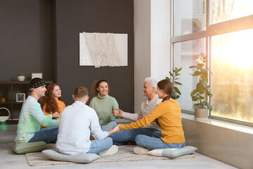 People holding hands on pillows at group therapy session