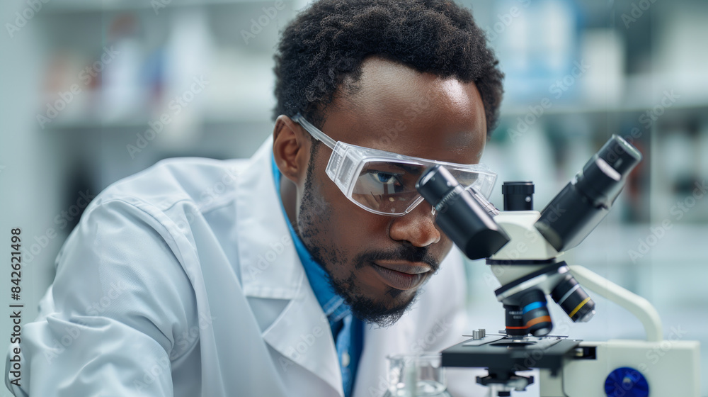 Aufkleber a thoughtful african american male scientist, wearing a lab coat and safety goggles, working with a 