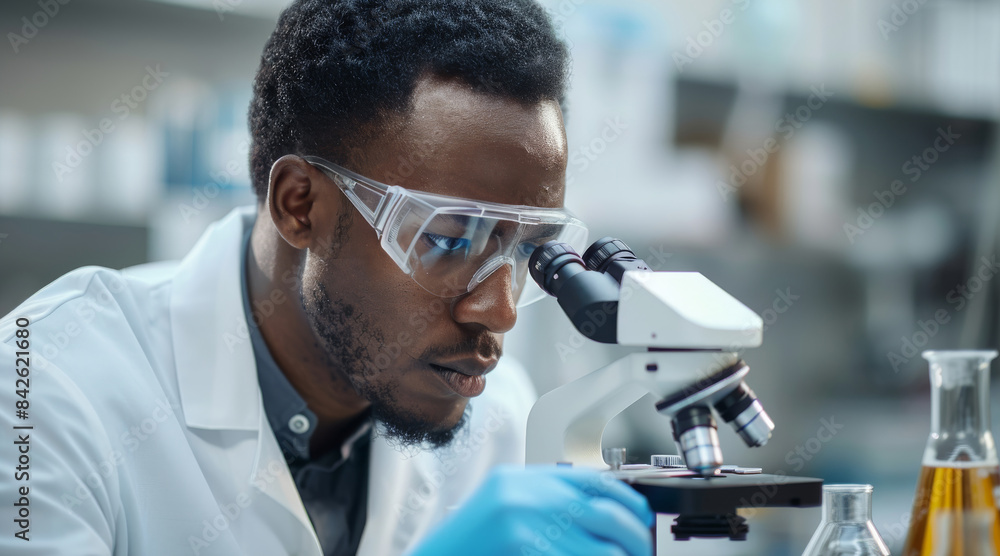 Aufkleber a thoughtful african american male scientist, wearing a lab coat and safety goggles, working with a 