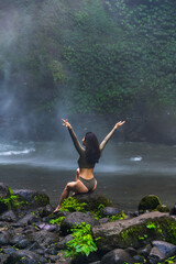 Woman in Grey Bodysuit Embracing Nature by Misty Waterfall