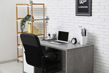 Stylish interior of white modern office with workplace, laptop and lamp
