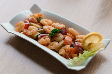 Shrimp salad with lemon on a white plate
