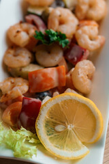 Shrimp salad with lemon on a white plate