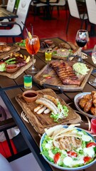 A festive table in a restaurant on a summer terrace with alcoholic drinks and meat and pork food