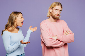 Young sad angry upset couple two friends family man woman wear pink blue casual clothes together spread hands scream shout cry argue isolated on pastel plain light purple background studio portrait.