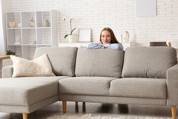 Young pretty woman near on sofa in stylish living room