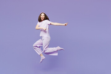 Full body young calm woman wear pyjamas jam sleep eye mask rest relax at home jump high point index...