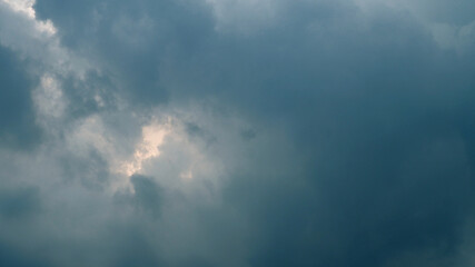 Dark blue cloud before rain. Abstract blue gradient of cloud sky with a sunset behind horizon. Landscape, scene, overcast, and storm concepts for wallpaper. Dramatic sky background in rainy season.