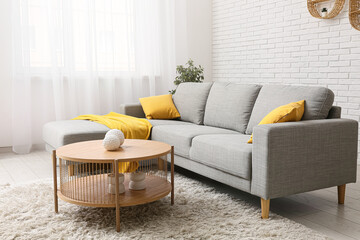 Interior of living room with grey sofa, coffee table and pillows