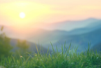 blurred background of grass in the foreground with a beautiful sunrise and mountain landscape