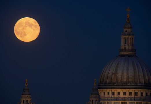 View of Saint Pauls Cathedral under a full moon, City of London, England.