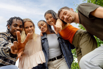 Portrait of multiracial group of generation z boys and girls looking at camera. Group of friends outdoors