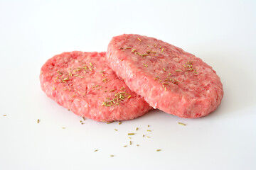 two hamburgers with seasoning on them isolated on white background  