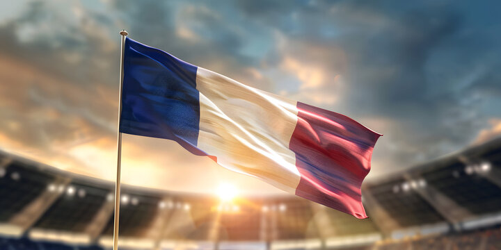 Flag of France waving in the wind, with a blurred soccer stadium in the background 