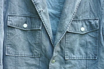 two pockets with iron buttons from a denim buttoned retro fashionable original gray men's long old jacket with a hole