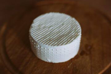 round feta cheese on wooden board