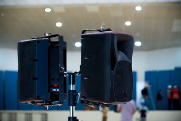 sound equipment speakers in a conference room, unrecognizable people working in the background. 
