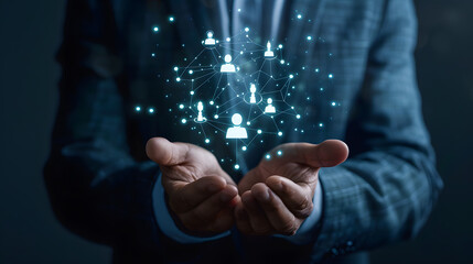 Businessman holding virtual icon of human with network connection and business team in dark background