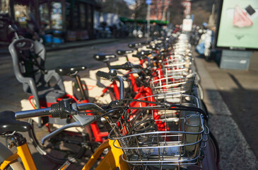 A row of bicycles are parked with their wheels neatly lined up, showcasing the different styles of bicycle tires and handlebars