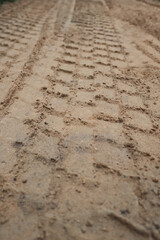 Sand tyre mark background. Tire tracks and footprints on beach sand. Machine Imprints.