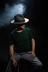 Mysterious, bearded man wearing a hat covering his face. Studio portrait.