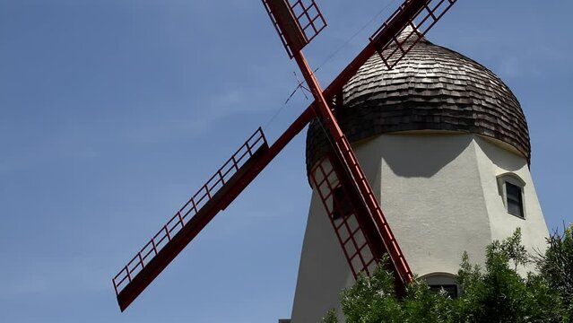 Solvang's Iconic Windmill Under a Clear Blue Sky, California. The picturesque scene captures the essence of this unique town, known for its Danish-inspired architecture and quaint atmosphere.