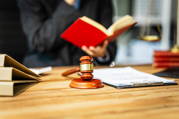 A young businesswoman is working at her desk, diligently preparing legal briefs and reviewing evidence for an upcoming trial, demonstrating her expertise as a lawyer in litigation and advocacy.