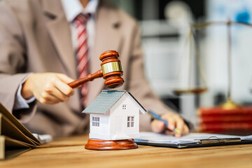A young businesswoman is working at her desk, reviewing contracts and preparing for litigation,...