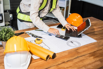 Female architect engineer is drafting blueprints using CAD software, focusing on sustainable...
