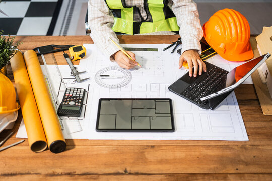 Female architect engineer is drafting blueprints using CAD software, focusing on sustainable infrastructure, renewable energy solutions, and adhering to building codes