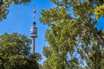 Fototapeta premium Vienna, Austria, August 17, 2022. The Danube Tower or Donauturm is the tallest building in Austria at 252 metres. It stands out among the trees of the park.