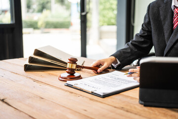 A young businesswoman is working at her desk, diligently preparing legal briefs and reviewing...