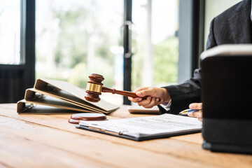 A young businesswoman is working at her desk, diligently preparing legal briefs and reviewing...