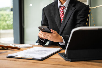 A young businesswoman is working at her desk, diligently preparing legal briefs and reviewing...