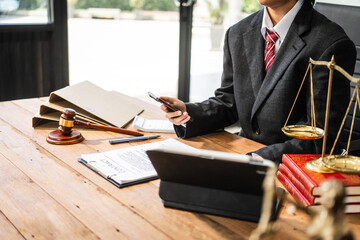 A young businesswoman is working at her desk, diligently preparing legal briefs and reviewing...
