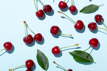 Ripe cherries or sweet cherries on a blue background. Top view. Space for text.