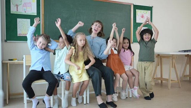 Portrait of a teacher and kids in a classroom where children have pleasure learning.