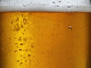 Closeup shot of an ice cold beer foam and bubbles.