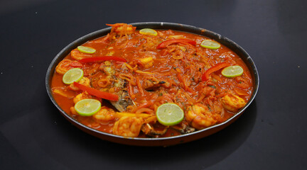 Traditional Creole Cajun court bouillon with fish and seafood gumbo chowder stew as top view in a pot with copy space right